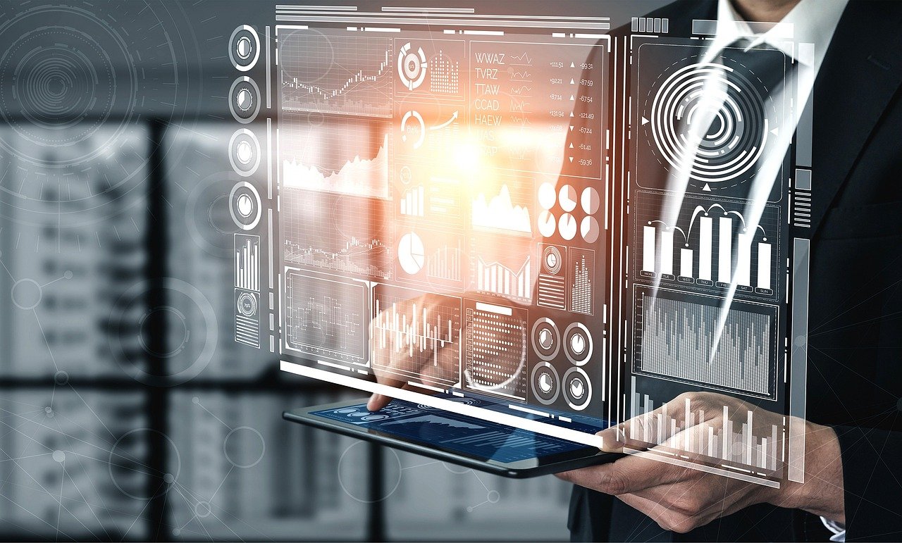 Businessman holding a tablet with a holographic business dashboard